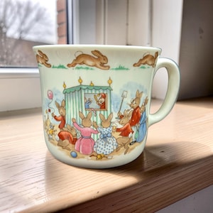 May include: A set of three ceramic mugs with a speckled, matte finish. The mugs are in shades of cream, light gray, and dark gray. Each mug has a simple, minimalist design, perfect for coffee or tea.
