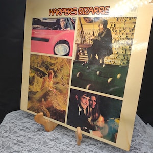 May include: A vintage vinyl record album cover featuring a collage of four images. The album is titled "Harpers Bizarre" in orange and black lettering. The images include a person driving a pink car, a person playing pool, a person sitting in a forest, and a couple sitting together.