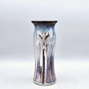 May include: A white ceramic mug with a black handle and the text "But First, Coffee" in a black, bold font. The mug is on a white surface.