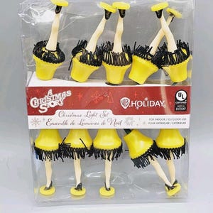May include: A Christmas Story themed light set featuring yellow lamps with black fringe and leg-shaped bases. The set includes the text "A Christmas Story" and "Christmas Light Set" on the packaging. For indoor/outdoor use.