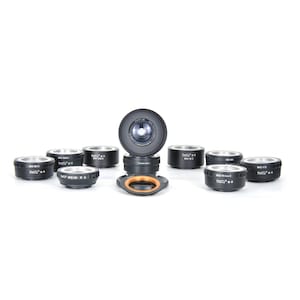 May include: A set of nine black camera lens adapters with a silver ring and the text "Fotodiox" printed on each. The adapters are arranged in a circle on a white surface. One adapter is larger than the others and has a clear glass lens.