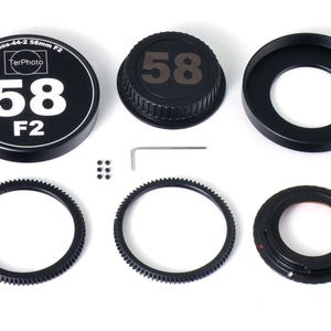 以下が含まれることがあります： レンズキャップ、レンズフード、ギアリング2つ、ステップアップリング、小型ドライバー、ネジ4本を含む、黒いカメラレンズアクセサリーのセット。レンズキャップとレンズフードには「58」の番号が付けられています。