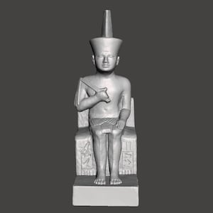 Peut inclure: Une statue en pierre grise d'un pharaon égyptien assis sur un trône. Le pharaon porte une haute couronne conique et un kilt. Le trône est décoré de hiéroglyphes.