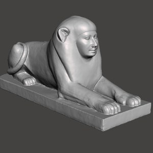 Peut inclure: Une sculpture en pierre grise d'un lion couché avec une tête humaine. Le lion est couché sur le ventre, les pattes tendues. La sculpture est sur une base rectangulaire.