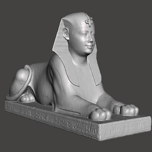 Puede incluir: Una escultura de piedra gris de una esfinge, una criatura mítica con cabeza humana y cuerpo de león. La esfinge está tumbada con las patas extendidas. La escultura es detallada y realista.