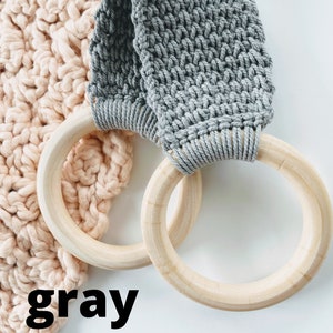 Puede incluir: Bucle de crochet gris con anillos de madera. El bucle de crochet est&aacute; unido a los anillos de madera. Los anillos son de madera natural.
