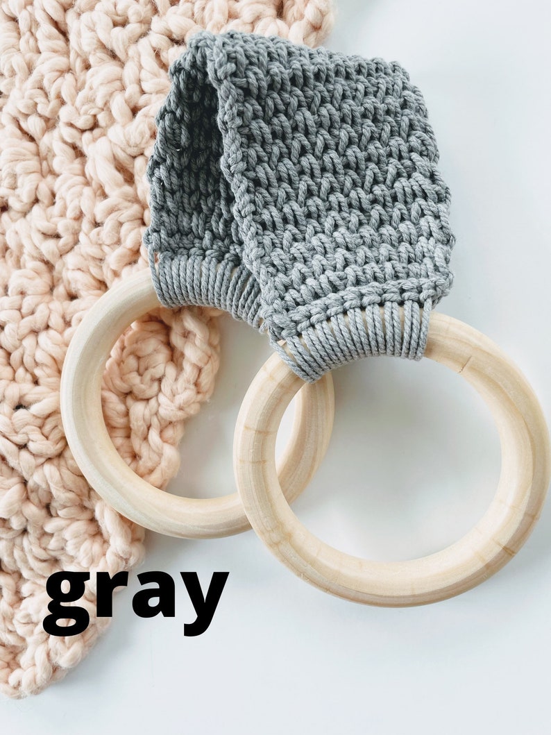 Puede incluir: Bucle de crochet gris con anillos de madera. El bucle de crochet est&aacute; unido a los anillos de madera. Los anillos son de madera natural.