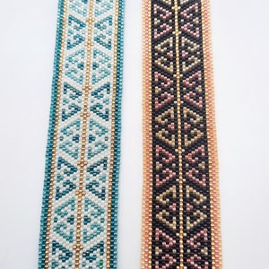 May include: Two beaded bracelets with geometric patterns. The bracelet on the left has a white background with blue and gold beads. The bracelet on the right has a black background with pink, gold, and black beads.