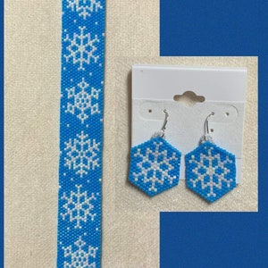 May include: A set of blue and white snowflake earrings and a matching bracelet. The earrings are dangle earrings with a hexagonal snowflake design. The bracelet is a beaded bracelet with a repeating snowflake pattern.