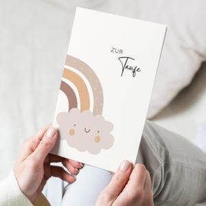 May include: A card with a rainbow and a cloud with a smiley face. The text on the card says "ZUR Taufe".