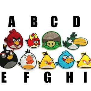 Puede incluir: Nueve parches bordados para planchar con personajes del videojuego Angry Birds. Los parches son de varios colores, incluyendo rojo, amarillo, verde, azul y negro. Los personajes incluyen a Red, Chuck, Bomb, Matilda y los cerdos.