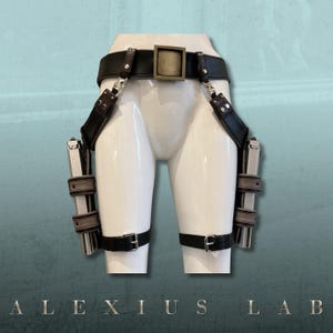 May include: Black leather gun holster with two silver-colored pistols. The holster includes a belt, shoulder straps, and leg straps with silver-colored hardware. The text "ALEXIUS LAB" is at the bottom.