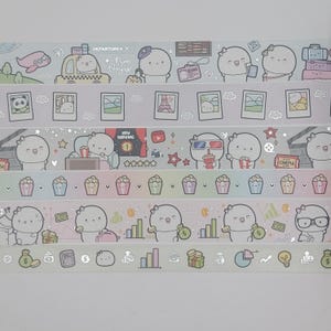 Puede incluir: Rollos de cinta adhesiva decorativa con lindos personajes de dibujos animados y temas de viajes, cine y finanzas. La cinta incluye imágenes de aviones, equipaje, palomitas de maíz y dinero. Los textos "DEPARTURES" y "Bon Voyage" son visibles.