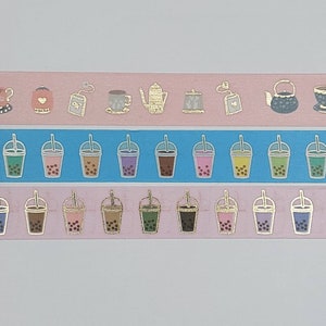 Puede incluir: Tres rollos de cinta washi con temática de té y boba. El rollo superior presenta un fondo rosa con teteras, tazas de té y bolsitas de té doradas. El rollo del medio tiene un fondo azul con tazas de boba doradas. El rollo inferior tiene un fondo rosa con tazas de boba doradas.