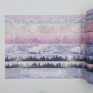 May include: A roll of washi tape with a repeating pattern of a cityscape, clouds, trees, and a moon and stars design. The tape is in shades of purple, pink, and blue.