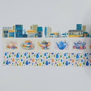 May include: Three rolls of washi tape featuring a city skyline, teapots with floral accents, and a repeating pattern of colourful raindrops.