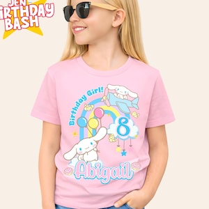 May include: Pink t-shirt with a cartoon graphic, rainbow, balloons, and the text "Birthday Girl!" and "Abigail". The number "8" is also displayed. The shirt has the text "Jen Birthday Bash" in a star.