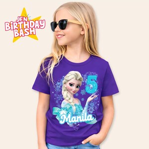 May include: A purple t-shirt featuring a cartoon image of Elsa from Frozen, with the number 5 and the name "Manila". The shirt also has the text "Jen Birthday Bash" in a star-shaped graphic.