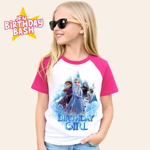 May include: White and pink raglan-sleeve t-shirt featuring a colorful graphic of characters from the movie Frozen. The shirt has the text "Birthday Girl" in blue. The text "Jen Birthday Bash" is in a yellow starburst.