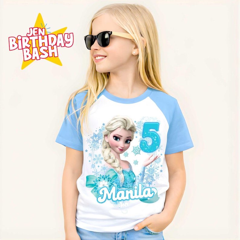 May include: A white and light blue raglan t-shirt featuring a graphic of Elsa from Frozen, the number 5, and the name "Manila". The shirt has the text "Jen Birthday Bash" in a starburst.