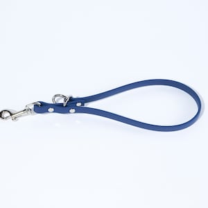 May include: A blue rubber dog lead with a silver clip and two silver rings.