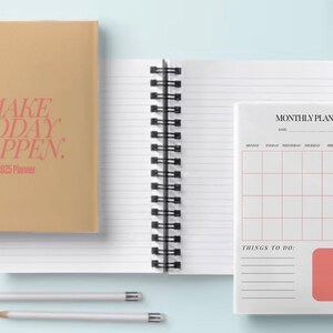 May include: Two spiral bound notebooks. The front cover of the first notebook is brown with the text "MAKE TODAY HAPPEN: 2023 Planner" in pink. The second notebook has a white cover with a monthly planner section and a to-do list section.
