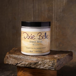 以下が含まれることがあります： 黒い蓋が付いた白いプラスチック製の瓶で、Dixie Mudが入っています。ラベルにはDixie Belle、Dixie Mud、White、Straight from the swamps of Dixie、8oz | 237mLという文字が記載されています。瓶は円筒形で、滑らかな白い仕上げと平らな上面が特徴です。