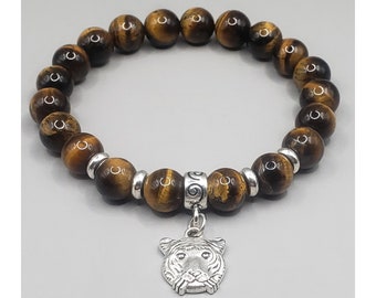 May include: A brown tiger eye beaded bracelet with a silver tiger charm. The bracelet has a silver spacer bead with a swirl design.
