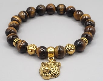 May include: A brown tiger eye beaded bracelet with gold accents and a gold tiger head charm.