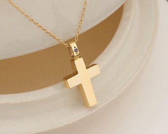 May include: A gold chain necklace with a small gold cross pendant. The cross has a single small diamond in the center.