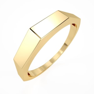 May include: A gold ring with a flat, octagonal top. The ring is smooth and polished.