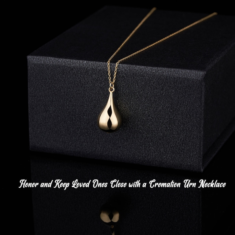 Gold teardrop cremation pendant displayed on black gift box with memorial message