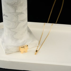 Puede incluir: Un collar de cadena de oro con un peque&ntilde;o colgante de mariposa. El colgante es de oro macizo y tiene un dise&ntilde;o detallado.