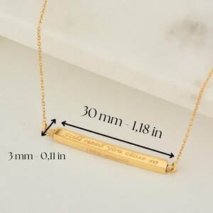 May include: Gold bar necklace with the inscription "Still need you close so". The bar is 1.18 inches long and 0.11 inches wide.