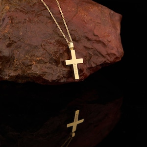 May include: A gold chain necklace with a gold cross pendant. The cross has the name "Jessica" engraved on it.