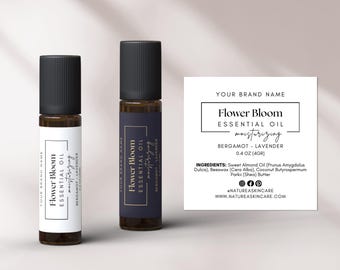 Pode incluir: Dois pequenos frascos de vidro castanho com tampas de rolamento pretas e etiquetas brancas. As etiquetas têm letras douradas e dizem "Flower Bloom Essential Oil hidratante Bergamota - Lavanda". Os frascos estão sobre um fundo branco com um cartão branco atrás deles. O cartão tem o texto "Your Brand Name", "Flower Bloom Essential Oil hidratante Bergamota - Lavanda", "0.4 oz (4gr)", "INGREDIENTES: Óleo de amêndoa doce (Prunus Amygdalus Dulcis), Cera de abelha (Cera Alba), Manteiga de karité (Butyrospermum Parkii)", "@natureaskncare", "www.natureaskncare.com".
