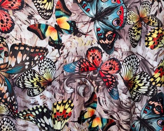 May include: A fabric with a repeating pattern of colorful butterflies. The butterflies have intricate wing patterns in shades of red, blue, yellow, and black, set against a neutral, textured background.