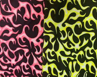 Puede incluir: Dos muestras de tela con un patrón de llamas. Una es negra con llamas rosas y blancas, la otra es negra con llamas amarillas y blancas. Los diseños de llamas son abstractos y cubren toda la superficie de la tela.