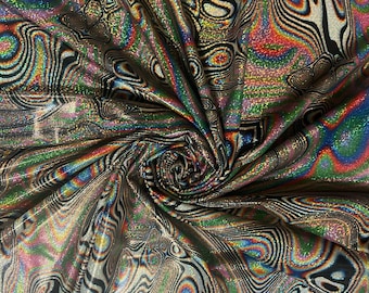 May include: A close-up of iridescent fabric with a swirling, abstract pattern in black and white. The fabric has a glittery finish and a rainbow sheen.