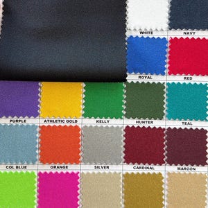 May include: A fabric swatch card featuring a large black fabric sample at the top, with a grid of smaller fabric swatches below. The swatches display a variety of colors, including white, navy, royal blue, red, purple, athletic gold, and more. Each swatch is labeled with its color name.