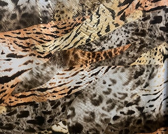 May include: A close-up of a fabric with a patchwork design of different animal prints. The fabric features a mix of brown, black, white, and beige tones. The prints include leopard, zebra, and snake.