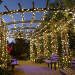 Lighted strands wrapped around posts by walk way and canopy