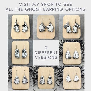 May include: Nine different pairs of ghost earrings on wooden display cards. Each pair features a different design, including a ghost holding a baseball bat, a ghost holding a soccer ball, a ghost holding a book, and a ghost holding a coffee cup. The text "9 DIFFERENT VERSIONS" is displayed in the center of the image.