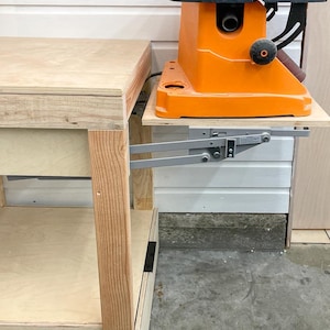 mixer lift in workbench with belt sander on top in raised position viewed from the side