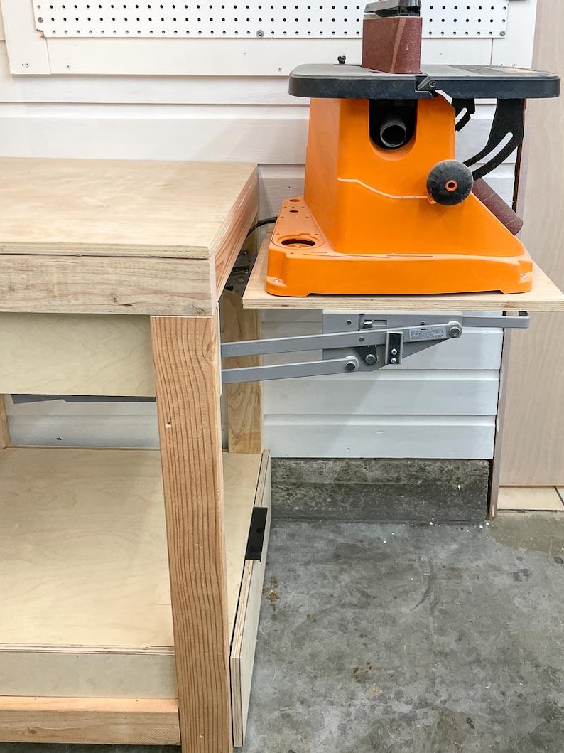 mixer lift in workbench with belt sander on top in raised position viewed from the side