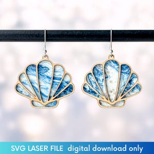 Puede incluir: Pendientes en forma de concha con marco de madera y diseño veteado azul y blanco. Los pendientes cuelgan de ganchos plateados. El texto "SVG LASER FILE digital download only" está en la parte inferior.
