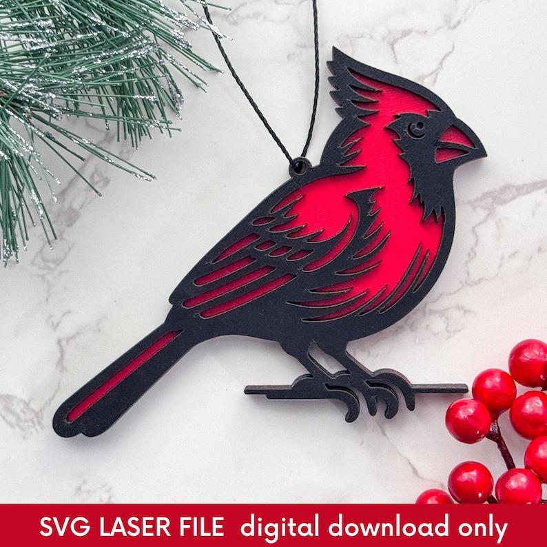 laser cut Christmas ornament of a red cardinal on a marble background