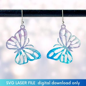 May include: A pair of blue and purple butterfly earrings with a silver hook. The earrings are made of a thin metal and have a delicate design.