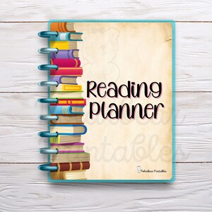 May include: A blue and beige reading planner with a stack of colorful books on the left side and the text "Reading planner" in pink letters. The planner has a spiral binding.