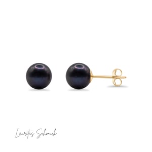 May include: A pair of black pearl stud earrings with gold posts and butterfly backs.